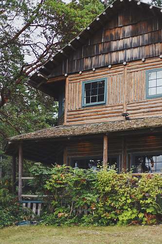 outdoors brown 2-storey house near plants housing