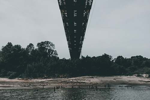 bridge gray bridge over body of water under white sky thebes