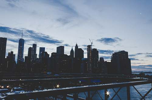 city lighted building under white clouds and blue sky urban