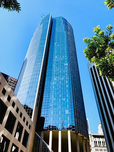 city low angle photo of blue glass curtain building office building
