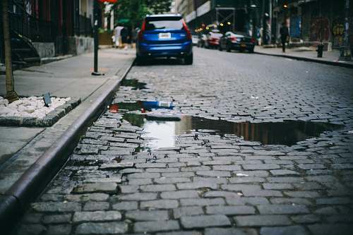 sidewalk cars parked beside the sidewalk during day time pavement