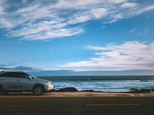 machine silver vehicle parked beside body of water spoke
