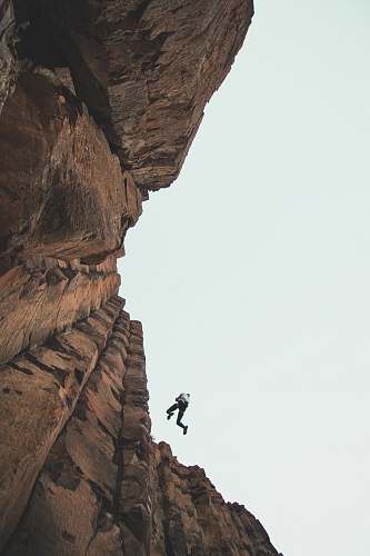 outdoors person climbing mountain during daytime vantage