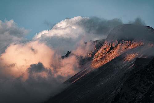 nature clouds enveloping brown rockhill during daytime outdoors