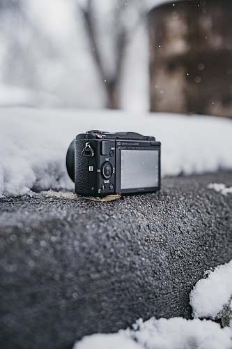 electronics black point-and-shoot camera on gray surface outdoor camera