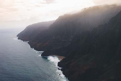 outdoors brown mountains under gray sky during daytime cliff