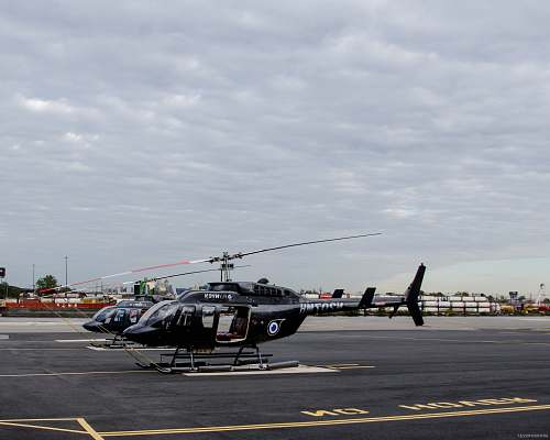 aircraft two black helicopters near on concrete pavement vehicle
