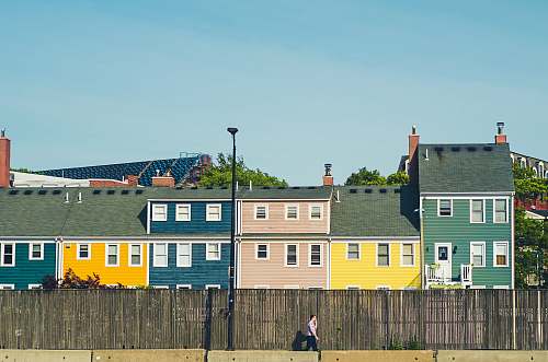 charlestown man walking beside multicolored apartments boston