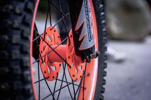 person black and orange motorcycle wheel and tire people