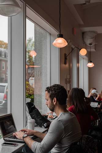 person man sitting and using laptop inside building sitting