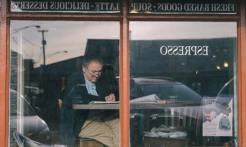 person man sitting on chair while writing on pape people