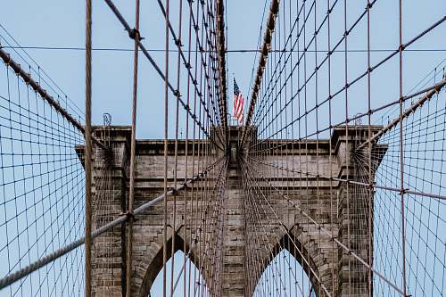 person USA flag on Brooklyn Bridge during daytime people