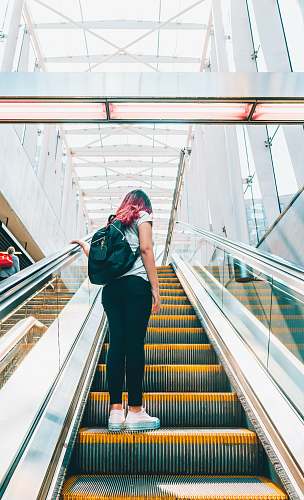 person woman standing on escalator people