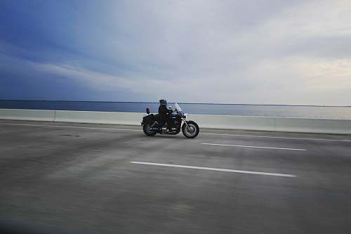 vehicle person riding touring motorcycle on gray concrete road transportation