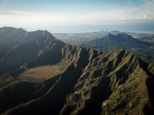 crest landscape photography of mountains surrounded by trees mountain range