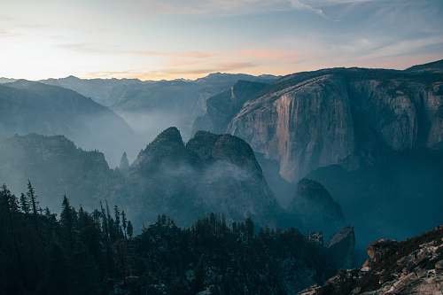 grey mountain covered with fog during daytime rock