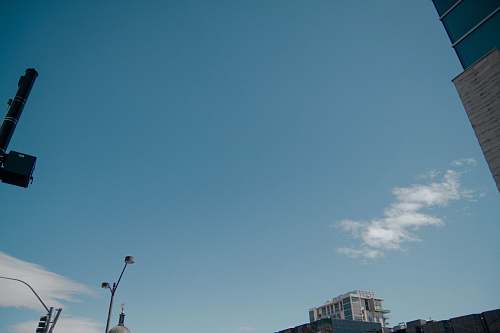 downtown gray building under blue sky and white clouds during daytime blue