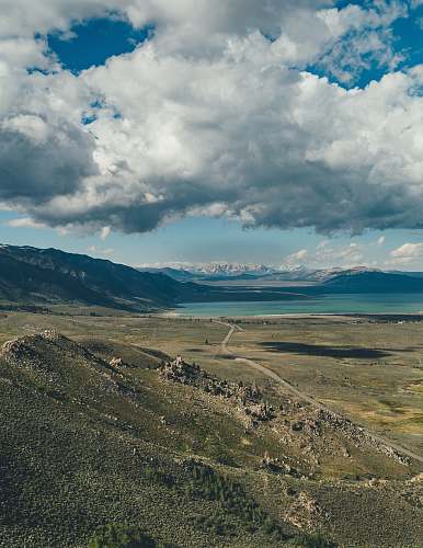 outdoors grey and white clouds hovering above valley and lake mountain
