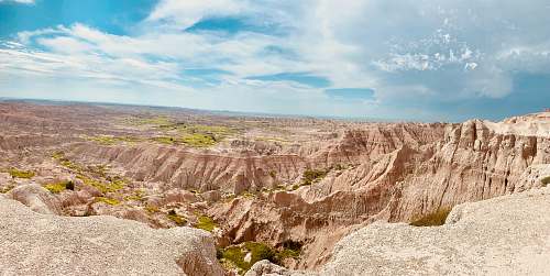 outdoors land formation under white clouds and blue sky during daytime mountain