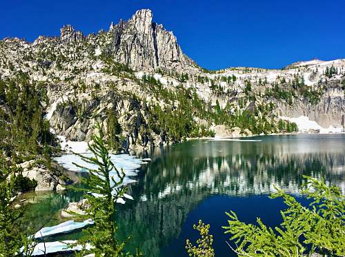 abies reflection of cliff on body of water during daytime fir