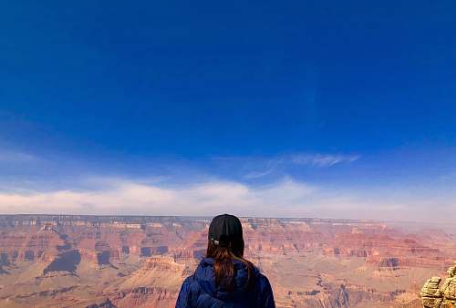 mountain woman wearing blue hoodie standing in front of mountain view outdoors