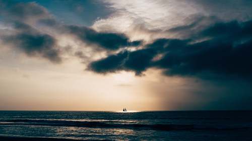 water calm sea under blue sky cloud