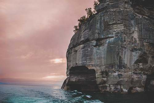 mountain gray rock formation at the sea with silhouette of trees cliff