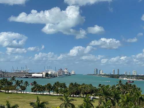 nature white ship on sea near city buildings under blue and white cloudy sky during daytime united states