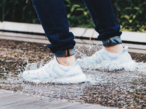 person person wearing pair of gray adidas UltraBOOST low-top sneakers stepped on pool of water human