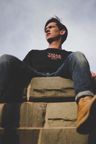 human man sitting on gray surface people