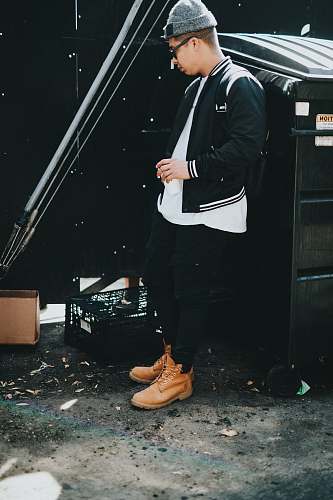 human man standing beside black metal dresser people