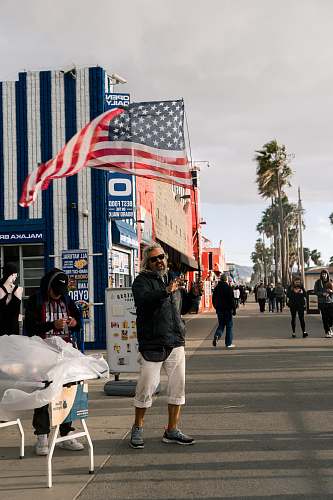building man standing near building and flag of America people