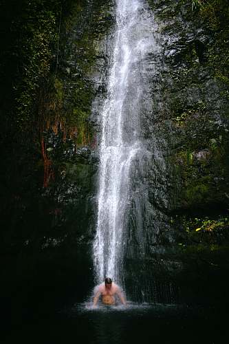 human man swimming under waterfalls people