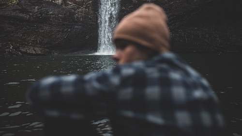 human person sitting beside waterfalls people