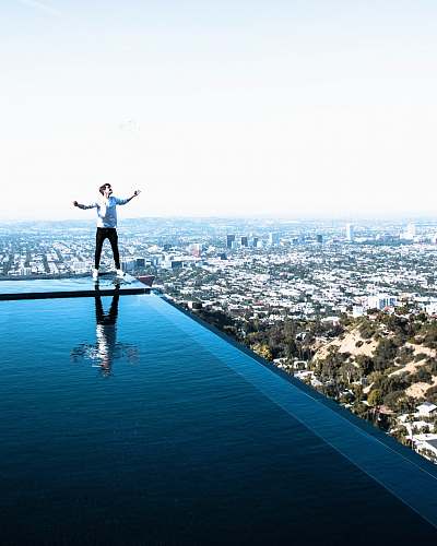 human person standing on edge of swimming on rooftop landscape