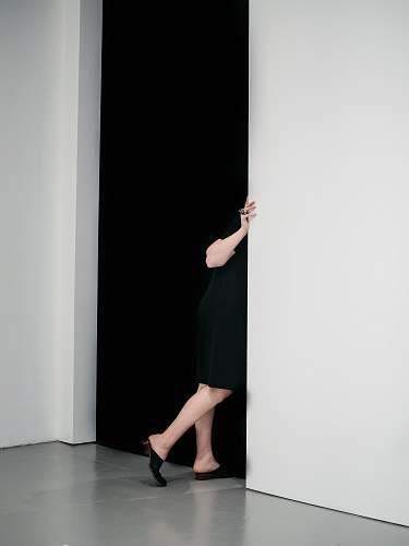 human woman standing sneaking on door inside white painted room people
