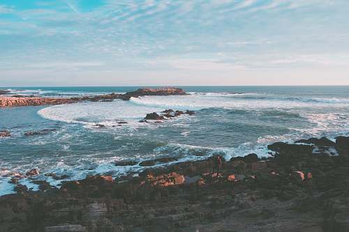 nature wavy ocean splashing on rock during daytime outdoors