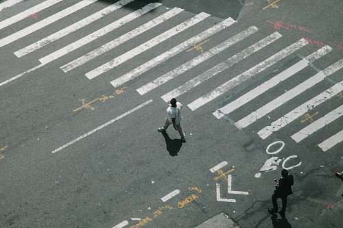 person two man walking on pedestrian lane during daytime human