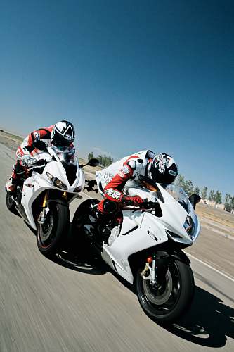 motorcycle two people riding sports bikes on gray asphalt road during daytime transportation