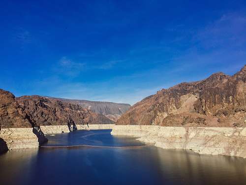 outdoors river cutting through the rocky mountains dam
