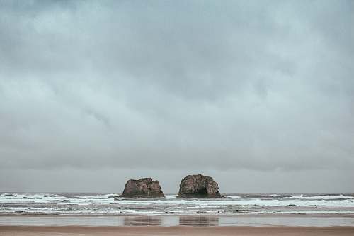 sea two gray rocks on body of water grey