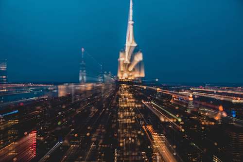 spire aerial photography of buildings under blue sky at night time steeple