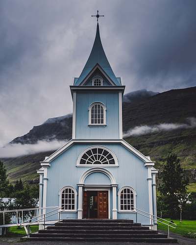 building blue and white wooden church during daytime spire