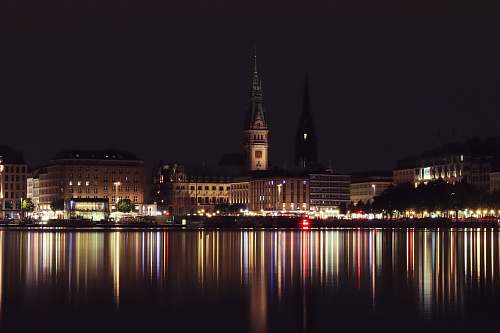 building body of water across city building during nighttime spire