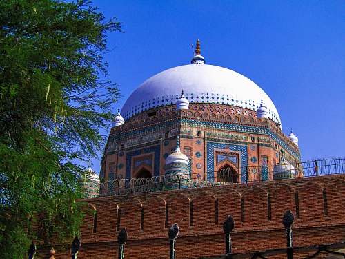 building brown and white dome building surrounded with tall and green trees dome
