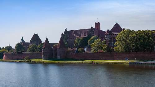 building brown castle near lake during cloudy day castle