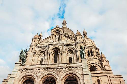 building brown cathedral under grey cloudy sky dome