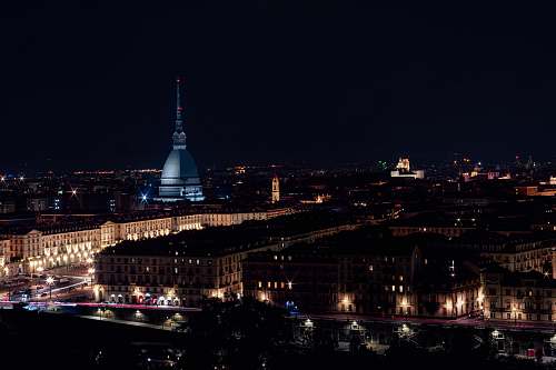 building brown concrete buildings during nighttime steeple