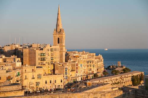 building brown concrete cathedral near sea during daytime spire