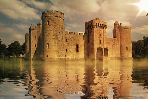 building brown concrete palace surrounded by body of water during daytime castle